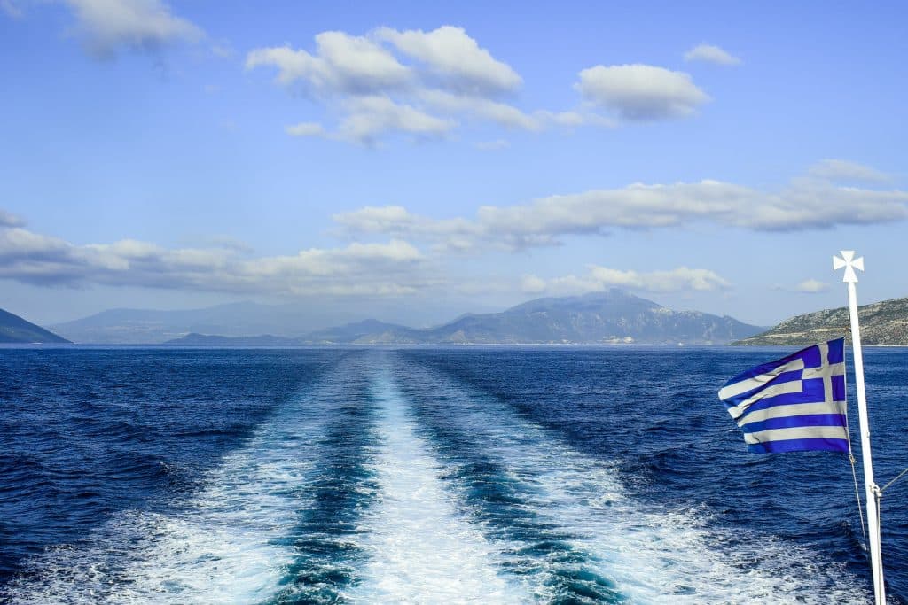 Blue sky and a boat with the Greek flag.