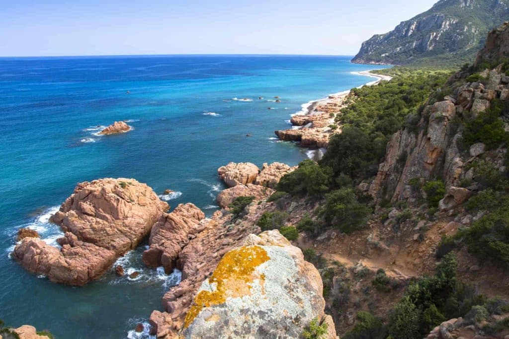 Costa rocciosa con acque cristalline in diverse tonalità di blu e verde